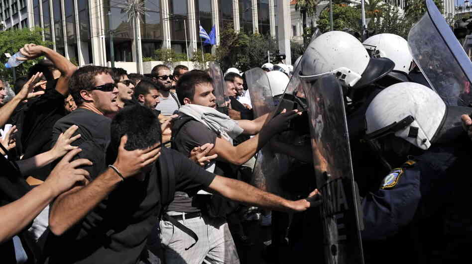 High school students protesting austerity measures clash with riot police in front of the Greek Parliament on Monday. Also Monday, the Greek government announced that it would not meet its targets for reducing the budget deficit. High school students protesting austerity measures clash with riot police in front of the Greek Parliament on Monday. Also Monday, the Greek government announced that it would not meet its targets for reducing the budget deficit.